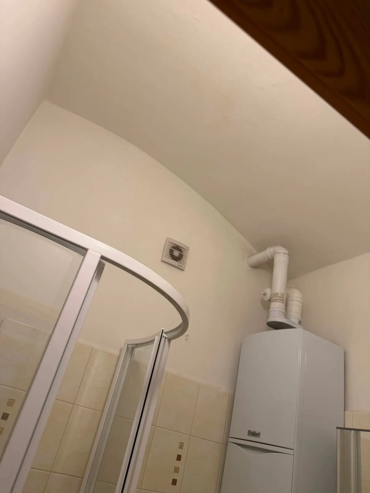 Vymalovaný strop a horní stěny v koupelně nad sprchovým koutem a plynovým kotlem.