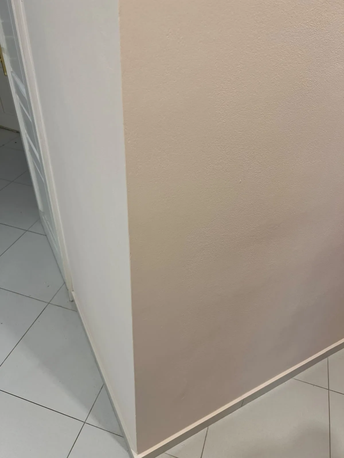 Hotová stěna v pudrově růžovém odstínu s čistě bílým rohem.