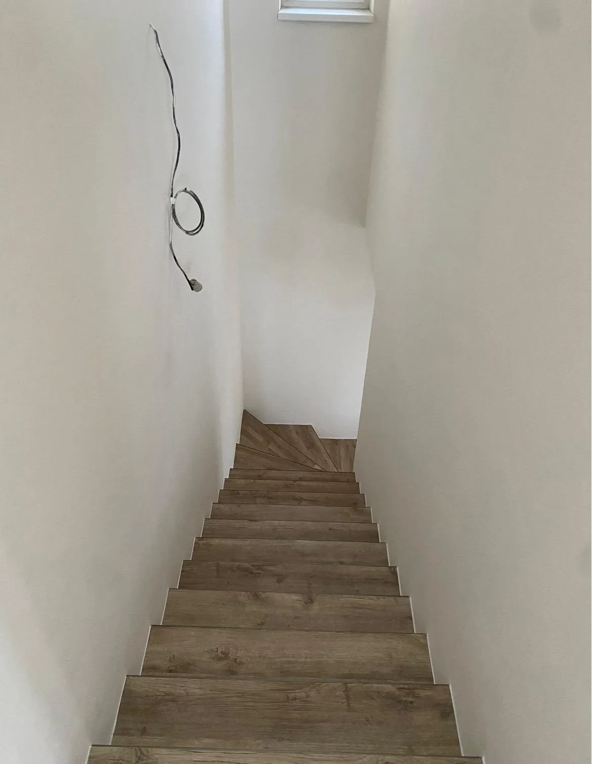 Vymalovane schodiště s dřevěnym schodištěm, pohled dolů.